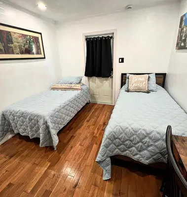 two beds in a room with wood floors at The Hub in Del Aire