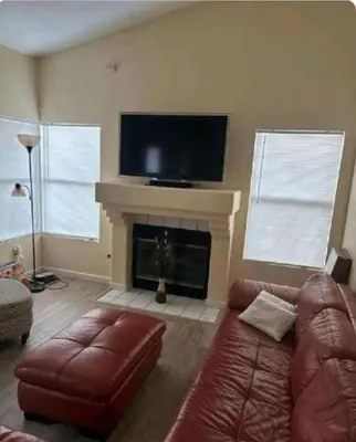 a living room with a couch and a fireplace at Be our Guest Hm Tampa in Palmdale