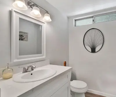 a white bathroom with a sink and a toilet at High Desert Dream on the Fairway WiFi Smart TVs in Victorville