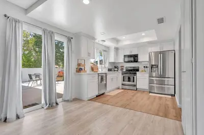 a kitchen with white cabinets and stainless steel appliances at High Desert Dream on the Fairway WiFi Smart TVs in Victorville