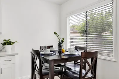 a dining room with a table and chairs and a window at Cozy Elegant Oasis With Parking in Los Angeles