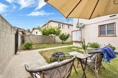a patio with a table and chairs and an umbrella at Cozy Elegant Oasis With Parking in Los Angeles