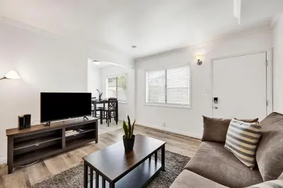 a living room with a couch and a flat screen tv at Cozy Elegant Oasis With Parking in Los Angeles