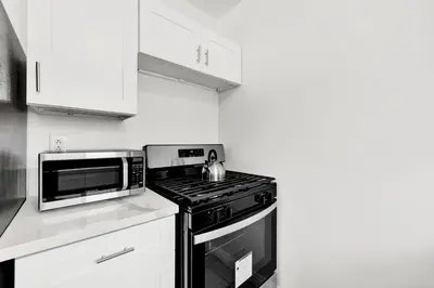 a kitchen with a black stove and a microwave at Cozy Elegant Oasis With Parking in Los Angeles