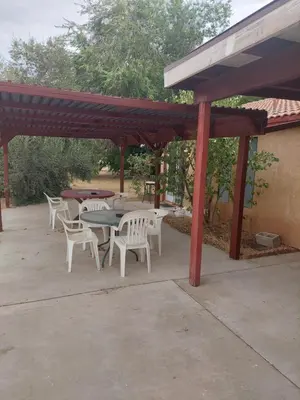 a patio with tables and chairs under a pavilion at Lyons lovely house in Hesperia