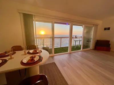 a living room with a table and a view of the ocean at Oceanfront 2BR 2BA with Stunning View 333 in Redondo Beach