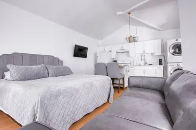 a bedroom with a bed and a couch and a kitchen at Cozy Private Studio in Granada Hills Near CSUN, Universal in Mission Hills