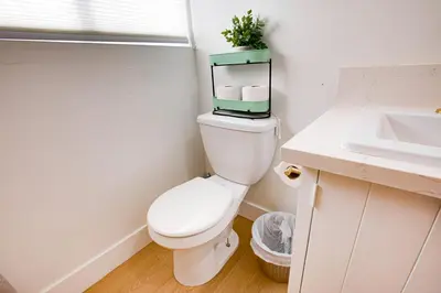 a white bathroom with a toilet and a sink at Cozy Private Studio in Granada Hills Near CSUN, Universal in Mission Hills