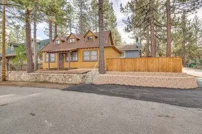 a yellow house with a wooden fence and trees at The Twin Pines Chalet, 2 min to Village, BBQ in Big Bear Lake