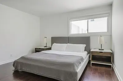 a white bedroom with a large bed with two night stands at Blueground Mid-Wilshire pool nr retail LAX-1266 in Los Angeles