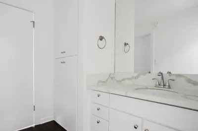 a white bathroom with a sink and a mirror at Blueground Mid-Wilshire pool nr retail LAX-1266 in Los Angeles