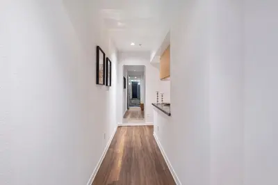 a hallway of a house with white walls and wooden floors at 14 Santa Monica Gorgeous Apartment in Los Angeles