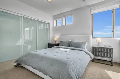 a bedroom with a large bed and large windows at Modern & chic in Heart of Downtown Santa Monica in Los Angeles