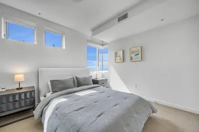 a white bedroom with a large bed and windows at Modern & chic in Heart of Downtown Santa Monica in Los Angeles