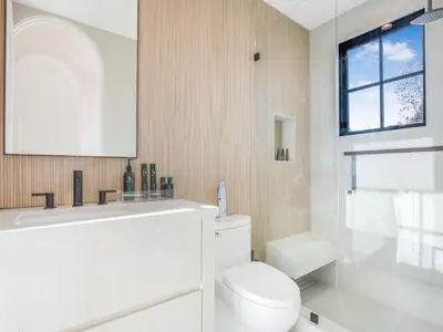a white bathroom with a toilet and a sink at Villa Camellia in Los Angeles