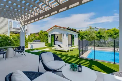 a patio with white furniture and a swimming pool at Villa Camellia in Los Angeles
