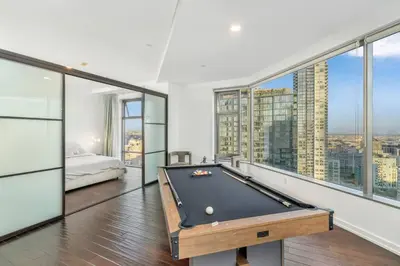 a bedroom with a pool table in a room with windows at Downtown LA with the breathtaking view 2 bedrooms and parking space in Los Angeles