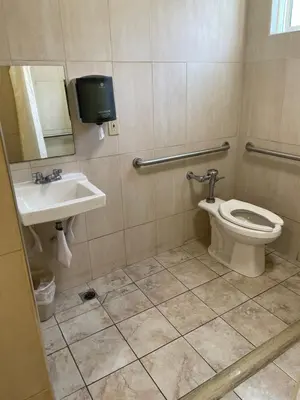 a bathroom with a toilet and a sink at Randolph Hotel in Huntington Park