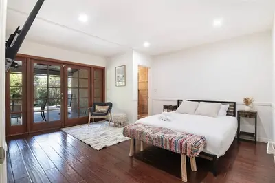 a white bedroom with a bed and a chair at 3-Bedroom Sherman Oaks House Near Universal Studios in Los Angeles