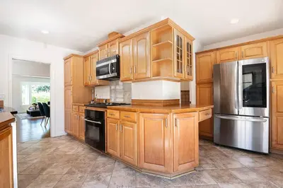 a kitchen with wooden cabinets and stainless steel appliances at 3-Bedroom Sherman Oaks House Near Universal Studios in Los Angeles