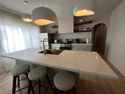 a kitchen with a large marble counter top and stools at 2 Bedroom Tulum Oasis in Hollywood in Los Angeles