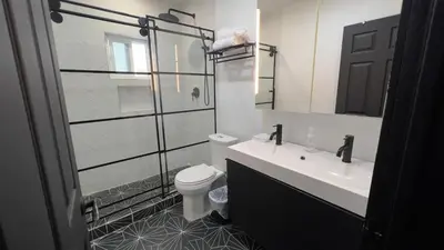 a bathroom with a toilet and a sink and a mirror at 2BR Lit and Spacious in the Heart of Hollywood in Los Angeles