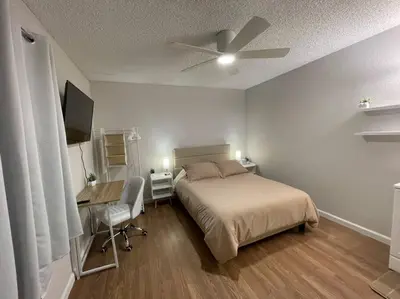 a bedroom with a bed and a desk and a ceiling fan at Pristine & Smart freshly remodeled house! in Lancaster