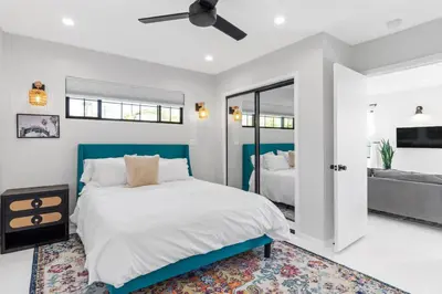 a white bedroom with a blue bed and a mirror at Bohemian Beach ## in Los Angeles