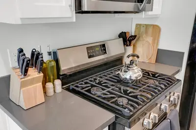 a kitchen with a stove with a tea kettle on it at 6th Haven, Arcade, King Bed, Games, 1 Mile to Beaches in Long Beach