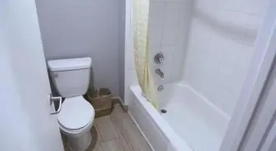 a bathroom with a toilet and a tub and a shower at Grand Park Inn in Baldwin Park