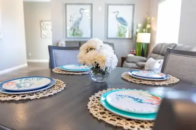 a dining room table with plates and flowers on it at Comfy and Stylish 4 Bathrooms 26 in Ridgecrest