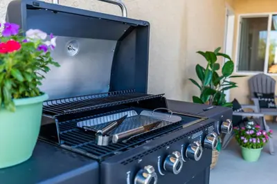 a black barbecue grill sitting on a table with flowers at Comfy and Stylish 4 Bathrooms 26 in Ridgecrest