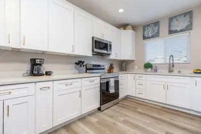 a white kitchen with white cabinets and white appliances at Comfy and Stylish 4 Bathrooms 26 in Ridgecrest