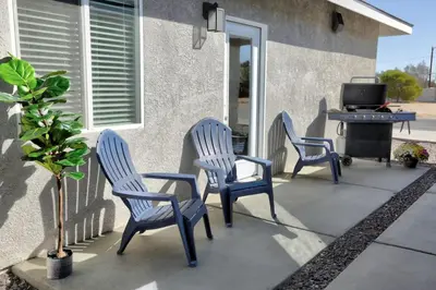 three blue chairs and a table on a patio at Luxury, Style and Comfort 4 Bathrooms 21 in Ridgecrest