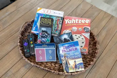 a basket filled with games and books on a table at Luxury, Style and Comfort 4 Bathrooms 21 in Ridgecrest