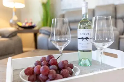 a tray with two wine glasses and a plate of grapes at Refreshing and Spotless 4 Bathrooms 22 in Ridgecrest