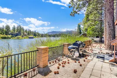 a group of birds sitting on a fence next to a river at Breezy estate #114 in Big Bear Lake