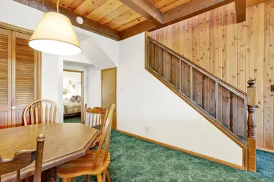 a dining room with a table and a staircase at Breezy estate #114 in Big Bear Lake