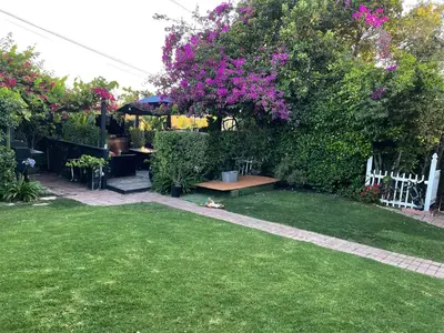 a yard with a garden with pink flowers and a fence at Inglewood Forum and Sofi park and walk private room in Inglewood