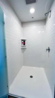 a bathroom with a shower and a white tile wall at Stunning Hollywood Sign View in Los Angeles