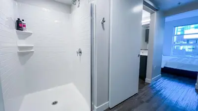 a white bathroom with a shower and a bed at Stunning Hollywood Sign View in Los Angeles