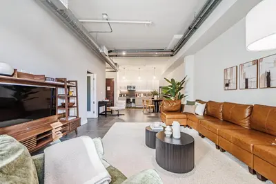 a living room with a couch and a tv at Downtown Escape - 2BR w Skyline Views & Hot Tub in Los Angeles