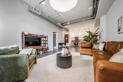 a living room with couches and a flat screen tv at Downtown Escape - 2BR w Skyline Views & Hot Tub in Los Angeles