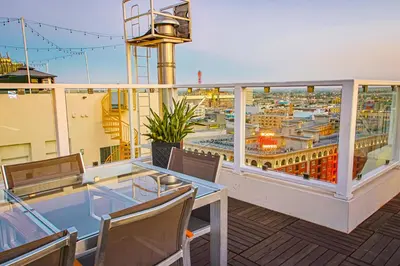a balcony with a table and chairs and a view of a city at Luxury 2BR in DTLA w Jacuzzi & Rooftop Views in Los Angeles
