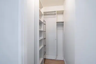 a walk in closet with white walls and shelves at Updated 3-Bedroom LA Home with Backyard, BBQ & Family-Friendly Amenities in Los Angeles