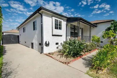 a white house with a driveway in front of it at Updated 3-Bedroom LA Home with Backyard, BBQ & Family-Friendly Amenities in Los Angeles