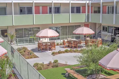 an external view of a building with tables and umbrellas at City Center Hotel By Kasa in Long Beach