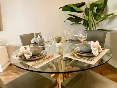 a glass table with plates and wine glasses on it at Lux One Bedroom Condo with Garden View in Los Angeles