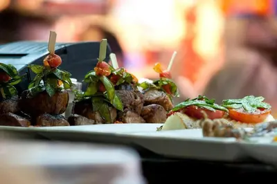 a plate of food with meat and vegetables on a table at Lux One Bedroom Condo with Garden View in Los Angeles