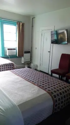 a hotel room with a bed and a flat screen tv at Stuart Hotel in Los Angeles